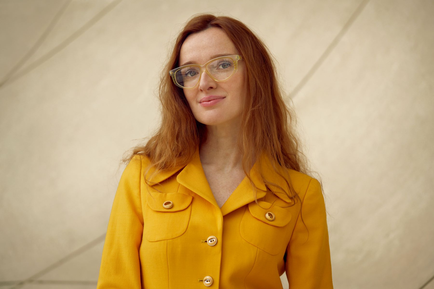 Natalia Romik - kobieta w okularach, ma długie rude włosy. Jest ubrana w żółtą koszulę.