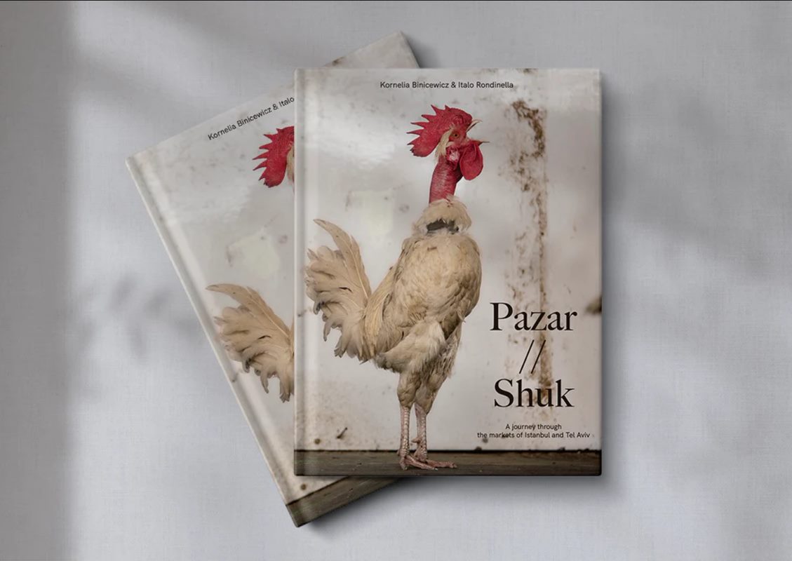 Dwie książki "Pazar // Shuk" leżą jedna na drugiej. Na okładce jest kogut.