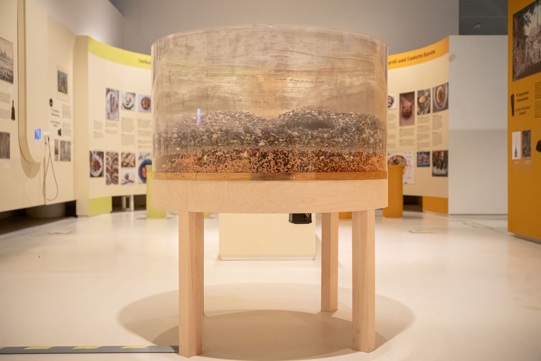 Stół II (Diaspora) autorstwa Anny Królikiewicz, który znajduje się na wystawie "Od kuchni". W plastikowym bębnie stołu mieszają się różne nasiona, np. fasoli i soczewicy.