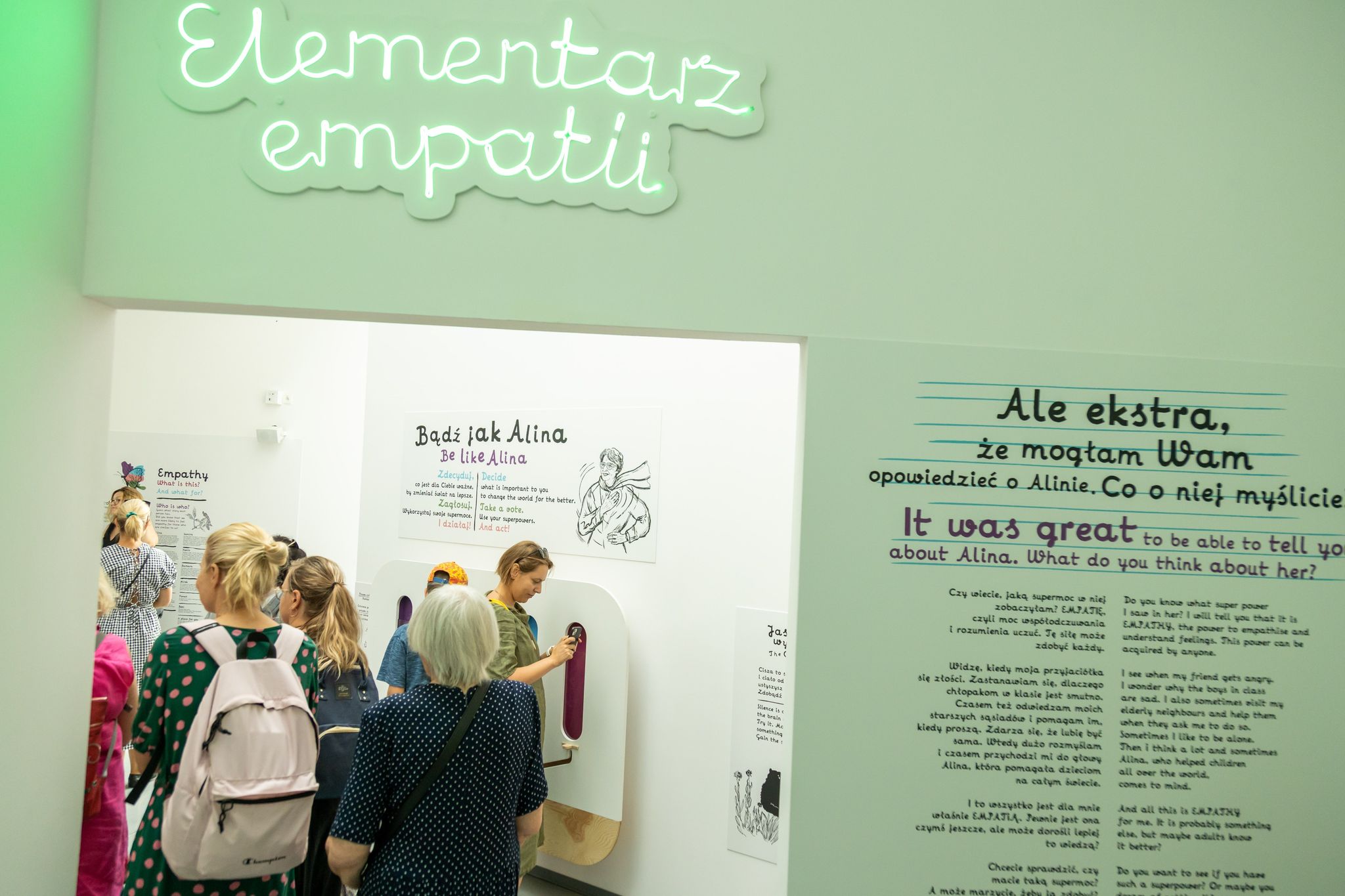 Grupa osób zwiedza wystawę "Elementarz empatii" w Łodzi.