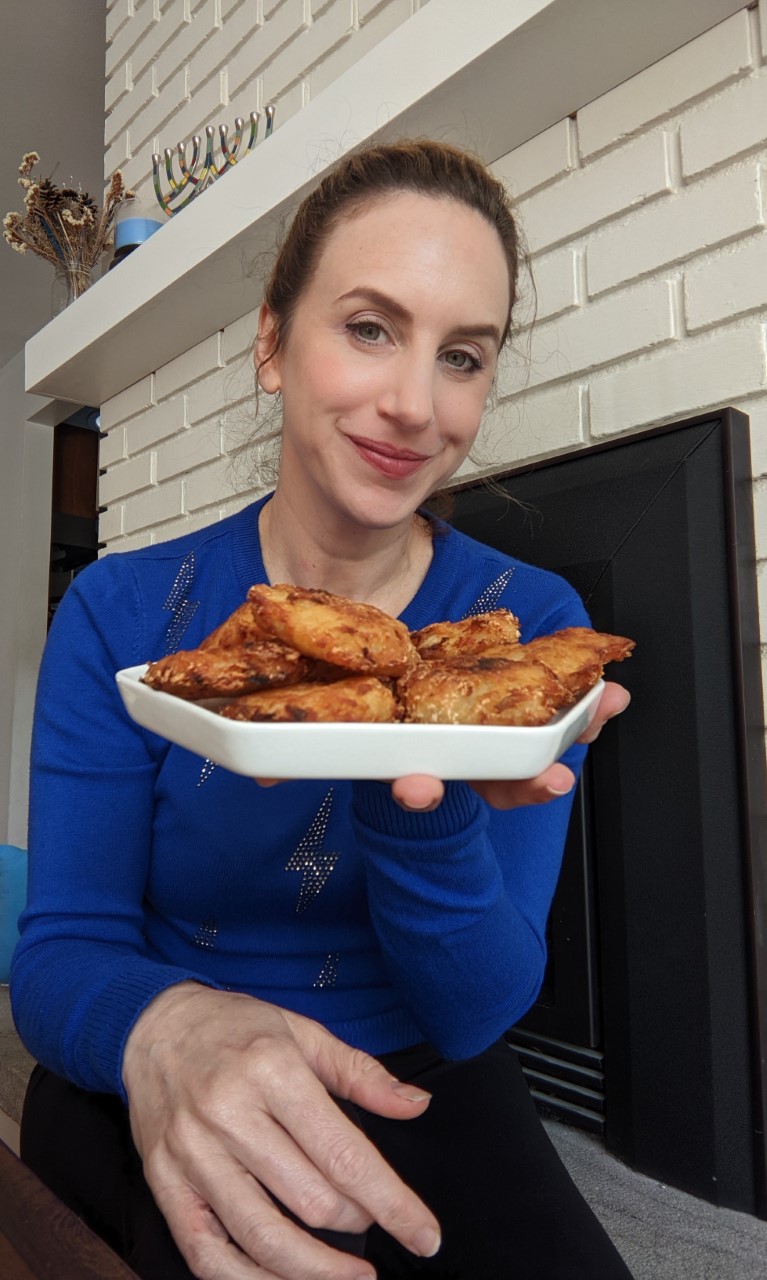 Rachel Manor holds a plate with her latkes
