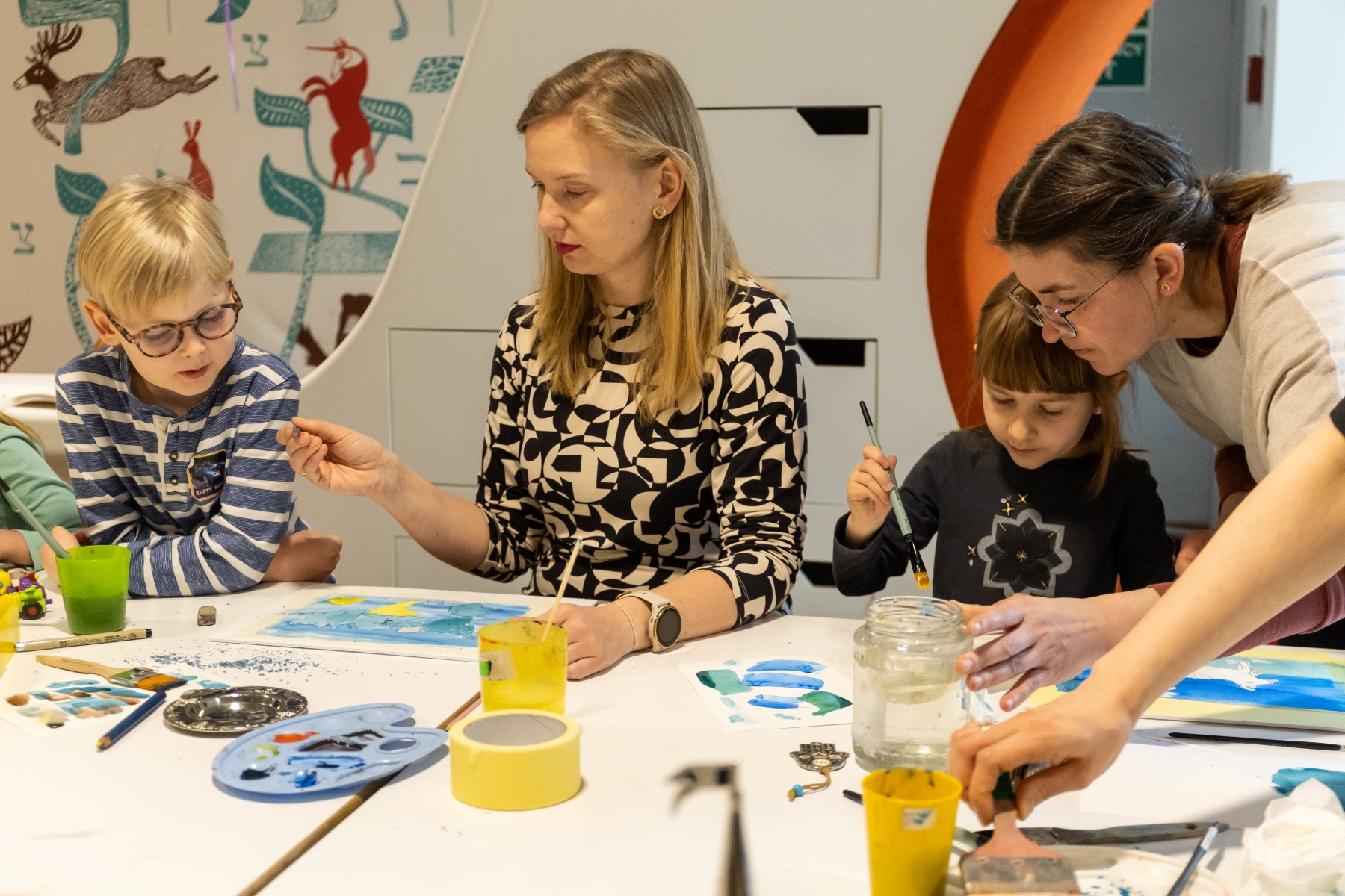 Dwie kobiety i dwoje dzieci malują ilustracje podczas warsztatów "Potwórz Sobie" w Muzeum POLIN.