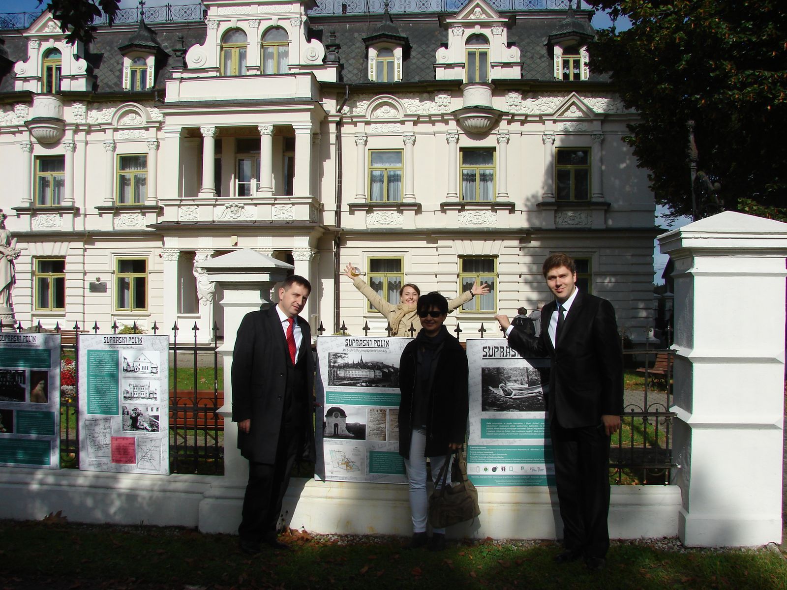 Trzy osoby stoją przed zabytkowym Pałacem Bucholtzów w Supraślu.