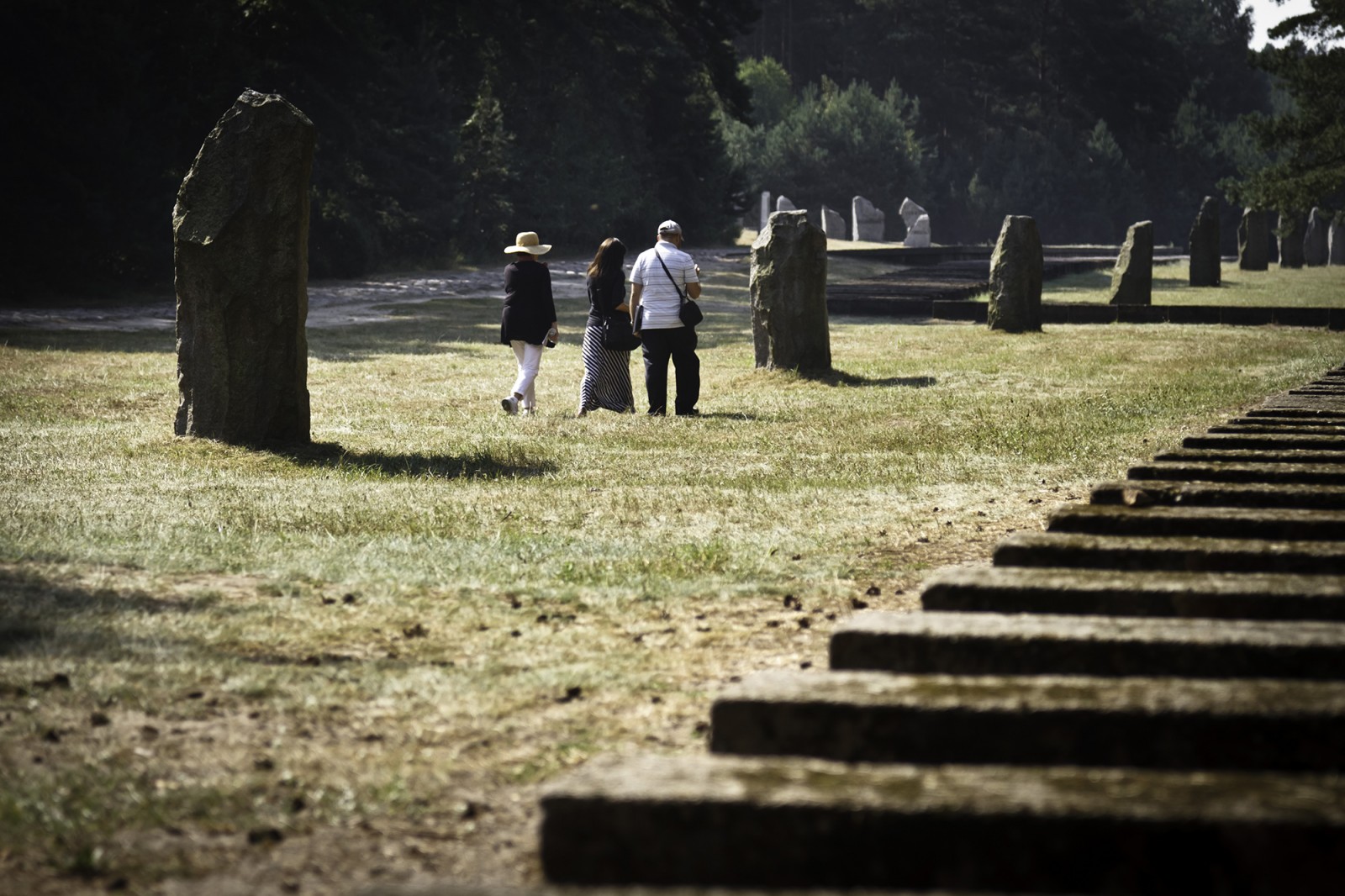 Kilka osób spaceruje po cmentarzu.