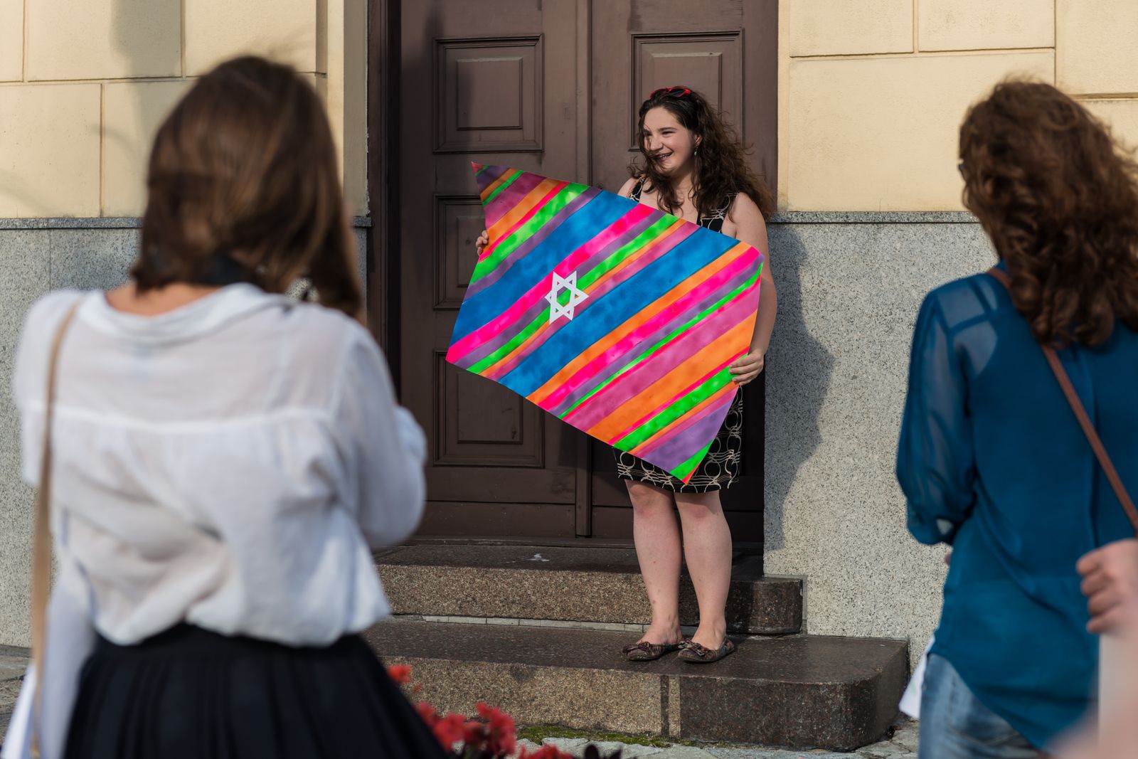 Warsztaty odkrywania historii stołecznych teatrów żydowskich - kobieta trzyma kolorową flagę.