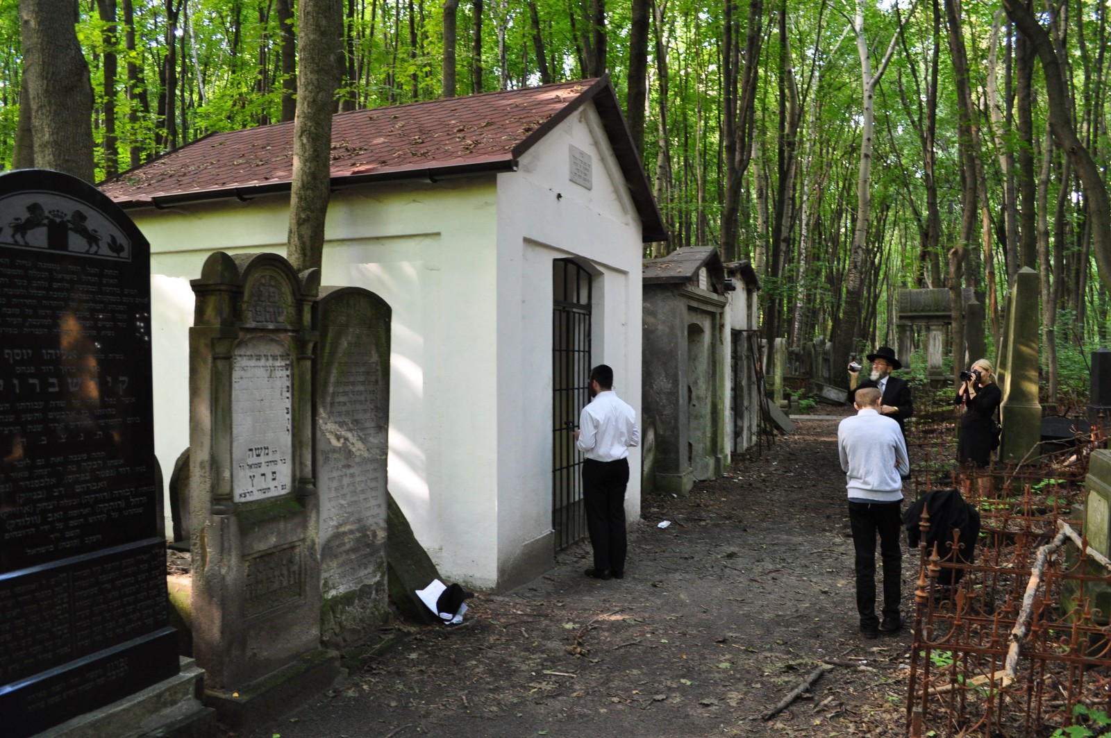 Dwóch mężczyzn stoi na ścieżce cmentarnej przy wejściu do grobowca