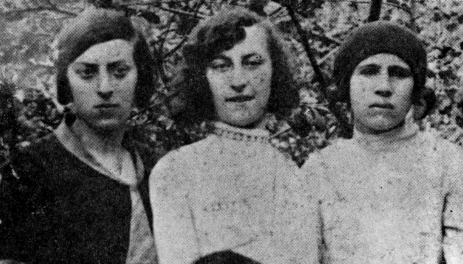 Czarno-biała fotografia przedstawia trzy kobiety. Patrzą przed siebie.