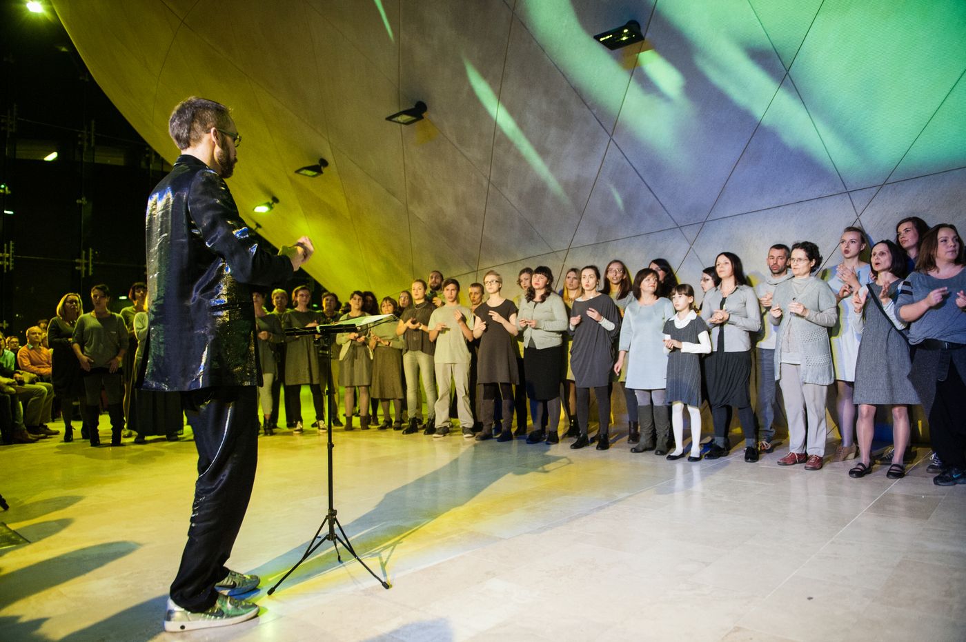 Koncert w Muzeum POLIN. Mężczyzna dyryguje chórem / zespołem.