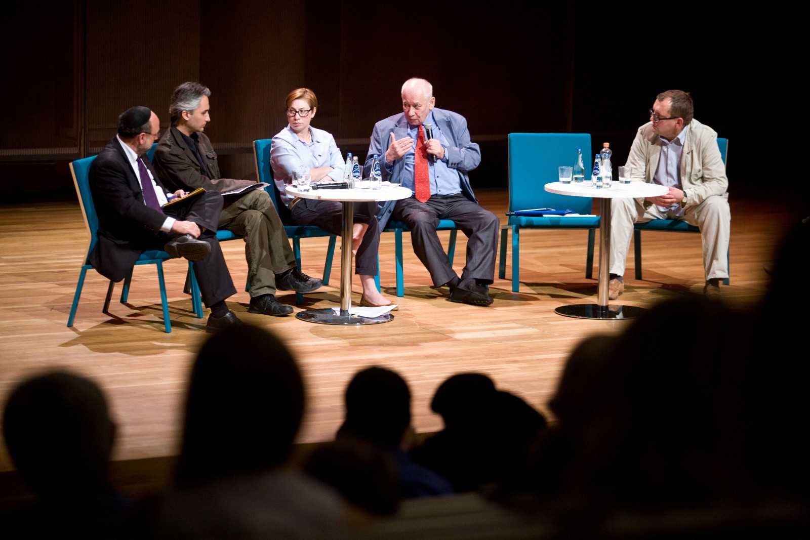Kilku panelistów siedzi na scenie podczas debaty o uboju rytualnym.