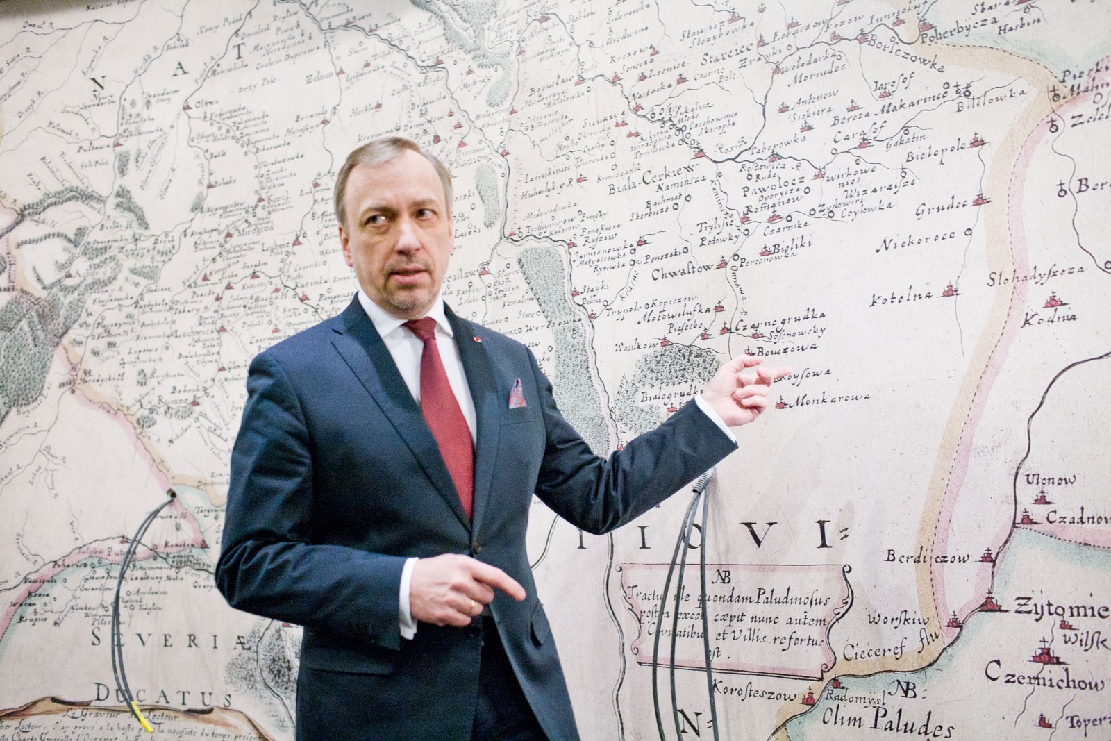 Bogdan Zdrojewski pokazuje coś na mapie na wystawie stałej w Muzeum POLIN.