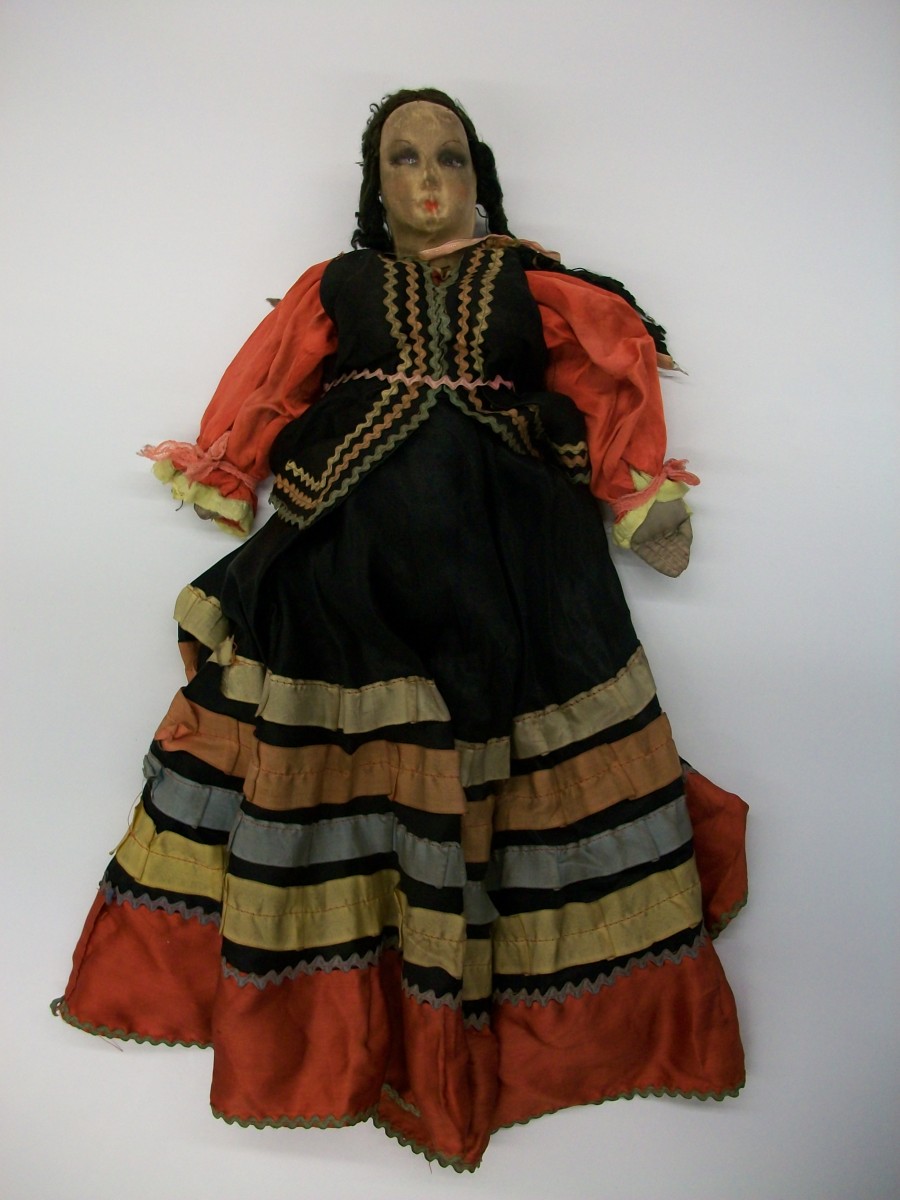 Szmaciana lalka ubrana w kolorową sukienkę.