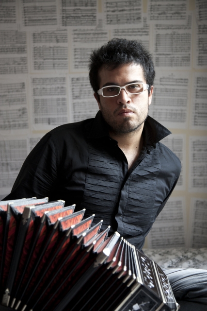 Juan Pablo Jofre Romarion siedzi z bandeonem na kolanach. Nosi okulary