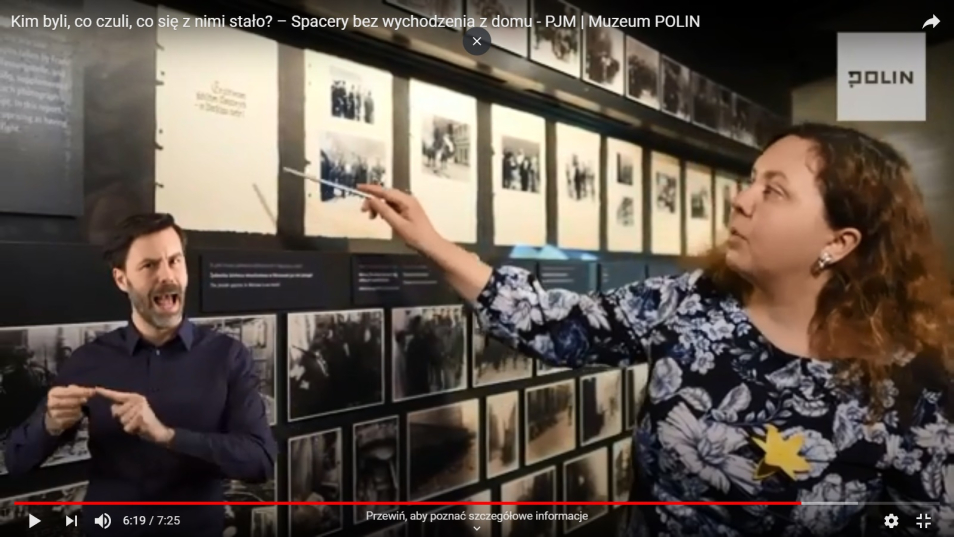 Po prawej stronie kobieta - Anita Borkowska, przewodniczka Muzeum POLIN - pokazuje na jedną z grafik, widoczną na ścianie po lewej stronie kadru. W lewym dolnym rogu tłumacz PJM.