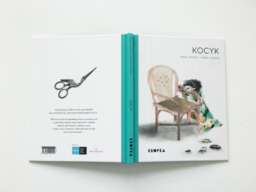 Okładka książki "Kocyk", ksiązka leży rozłożona, grzbietem do góry, widać przednią i tylną okładkę, z napisami:  Miguel Gouveia, Raquel Catalina "Kocyk"