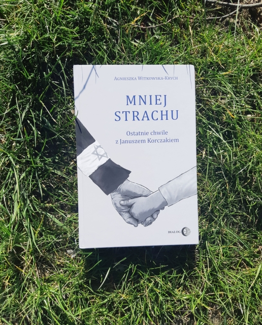 Okładka książki: Agnieszka Witkowska-Krych "Mniej strachu. Ostatnie chwile z Januszem Korczakiem". Książka leży na trawie