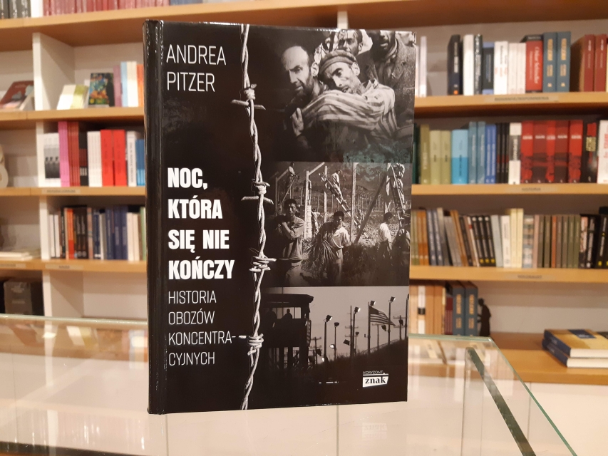 Okładka książki Andrea Pitzer "Noc, która się nie kończy. Historia obozów koncentracyjnych". W tle regał księgarniany, z wieloma innymi książkami