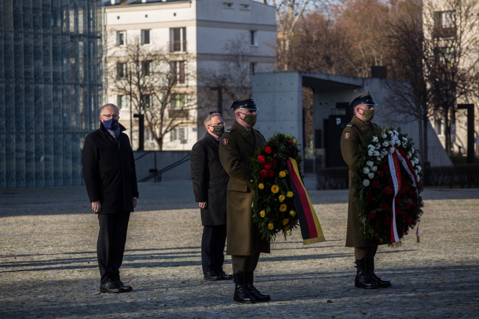 Szef Urzędu Prezydenta Federalnego Republiki Federalnej Niemiec Stephan Steinlein oraz szef gabinetu Prezydenta RP Krzysztof Szczerski podczas złożenia wieńca przed pomnikiem Bohaterów Getta Warszawskiego przed nimi żołnierze w mundurach galowych niosą wieńce z kwiatów