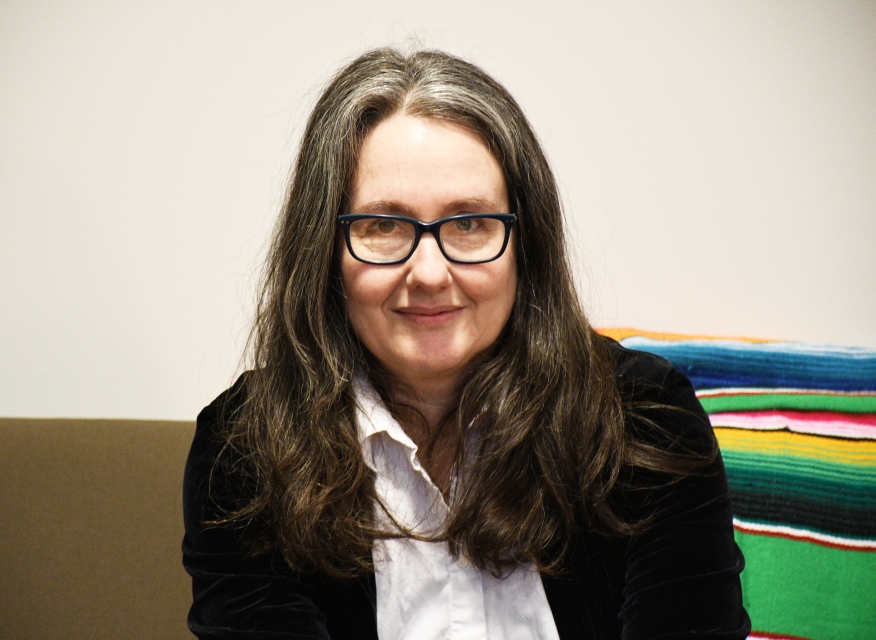 Portret kobity - Naomi Seidman - długie cimne włosy, okulary, ciemna marynarka i biała koszula.