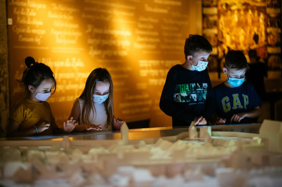 Dzieci w maseczkach nad makietą Krakowa i Kazimierza na wystawie stałej Muzeum POLIN