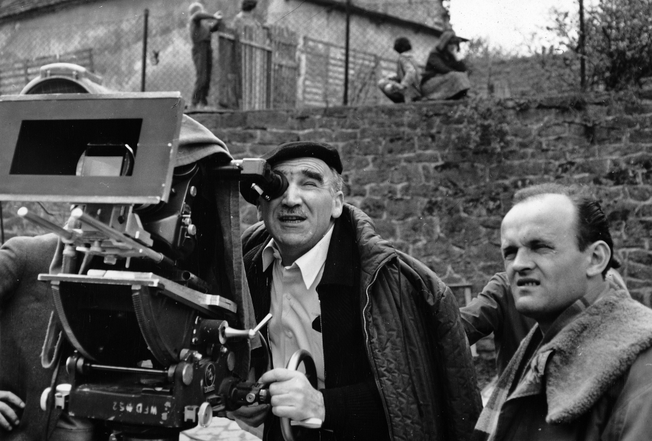 Czarno-biała fotografia. Aeksander Ford patrzy w wizjer dużej kamery, obok stoi drugi mężczyzna