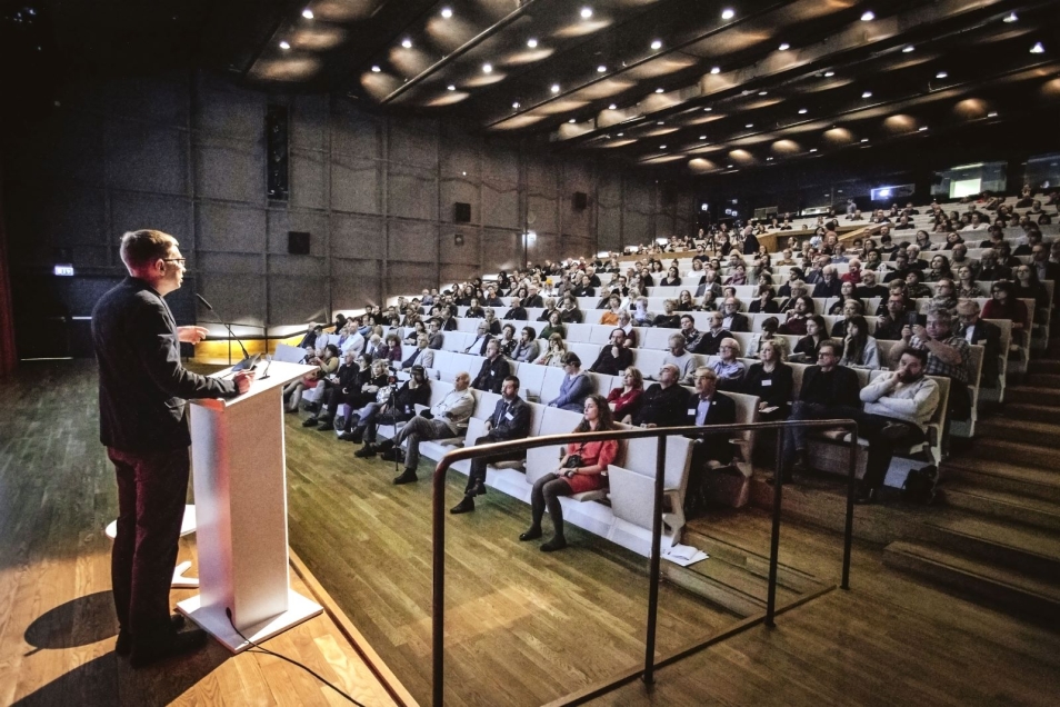 Audytorium Muzeum POLIN. Prelegent stoi przy mównicy podczas konferencji.