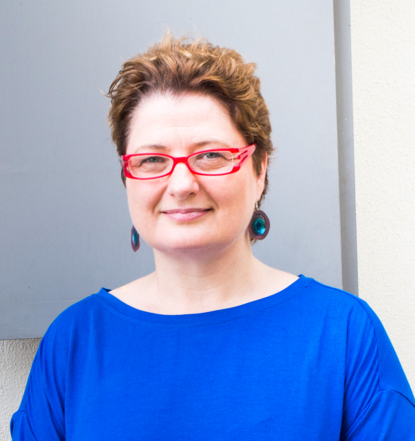 Natalia Aleksiun. Krótko ścięta brunetka w czerwonych okularach.