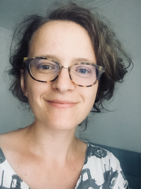Marta Sapała - krótko ścięta brunetka w okularach z lekko kręconymi włosami.