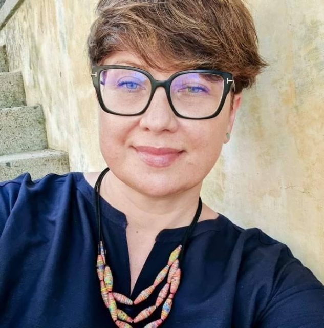 Renata Hryciuk - krótko ścięta ciemna blondynka w okularach.
