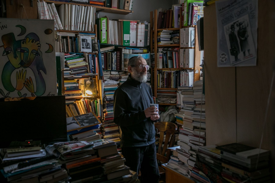 Stanisław Krajewski, starszy mężczyzna z brodą, w pokoju pełnym książek.