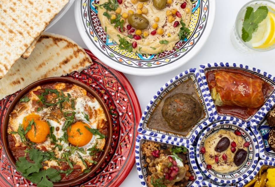 Na talerzach mezze izraelskie, szakszuka, pita i hummus.
