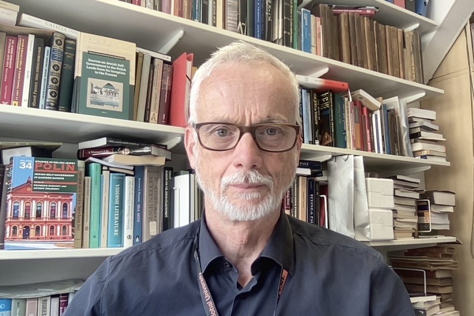 François Guesnet na tle domowej biblioteczki.