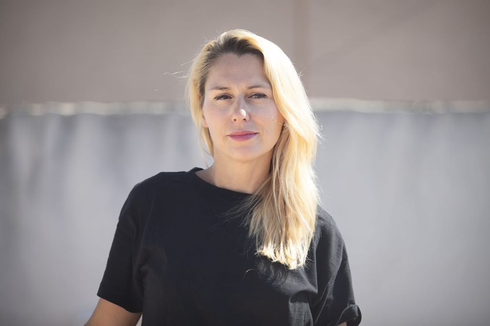 Kornelia Binicewicz stoi na tle szarej ściany.