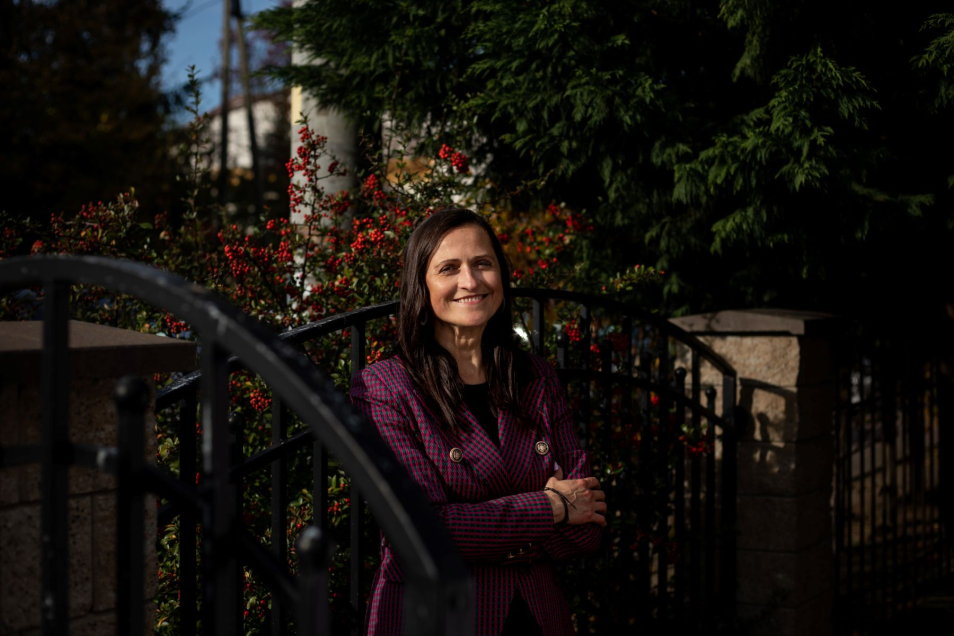 Jolanta Drab stoi przy metalowej bramie.