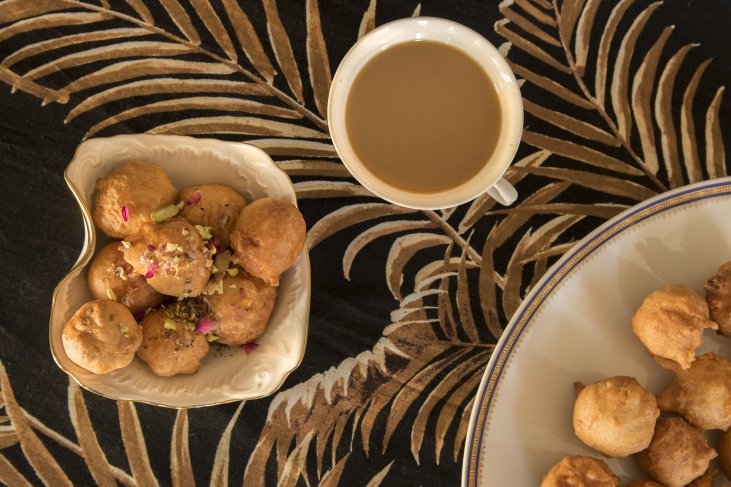 Mini doughnuts in a bowls and coffee in the cup.