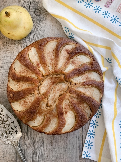 Beth Lee's pear cake on the table. Next to it there is a pear.