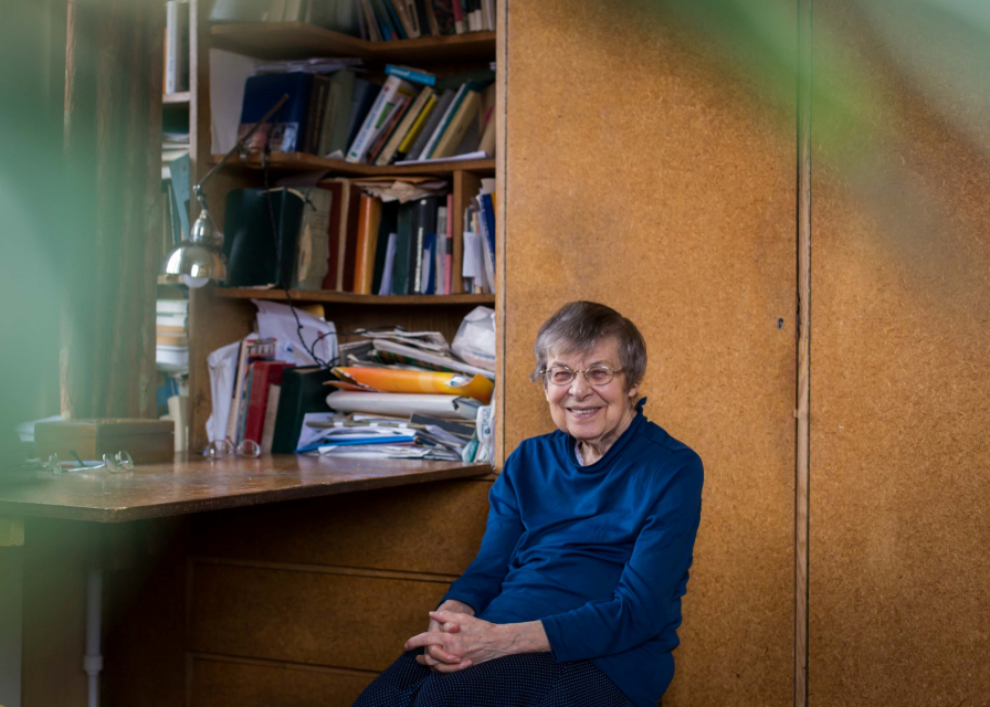 Barbara Góra siedzi przy biurku w mieszkaniu. Kobieta uśmiecha się.