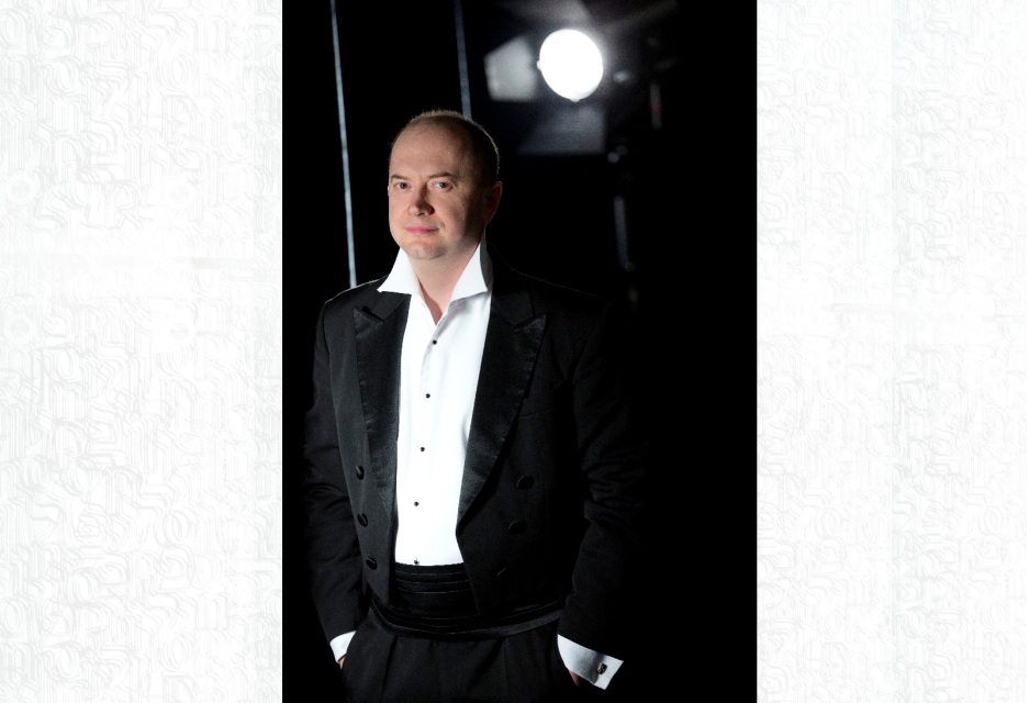 Michał Klauza w białej koszuli i garniturze
