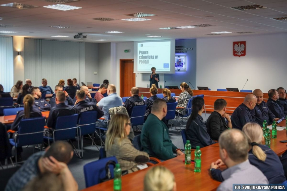 Grupa policjantów siedzi w sali wykładowej podczas szkolenia na temat praw człowieka w Policji.