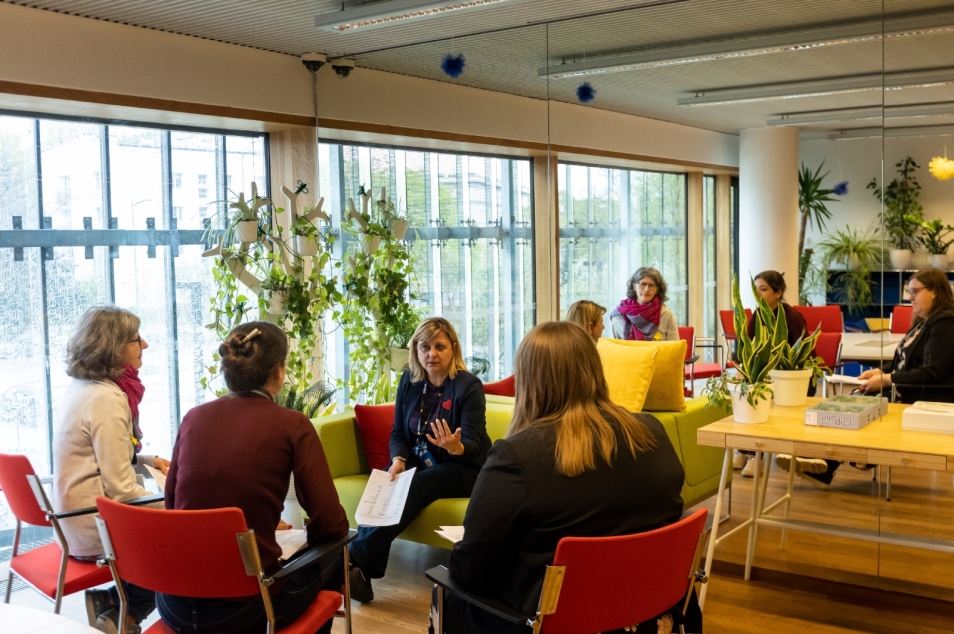 Grupa kobiet siedzi w kole i rozmawia ze sobą podczas seminarium w ramach projektu Erasmus.