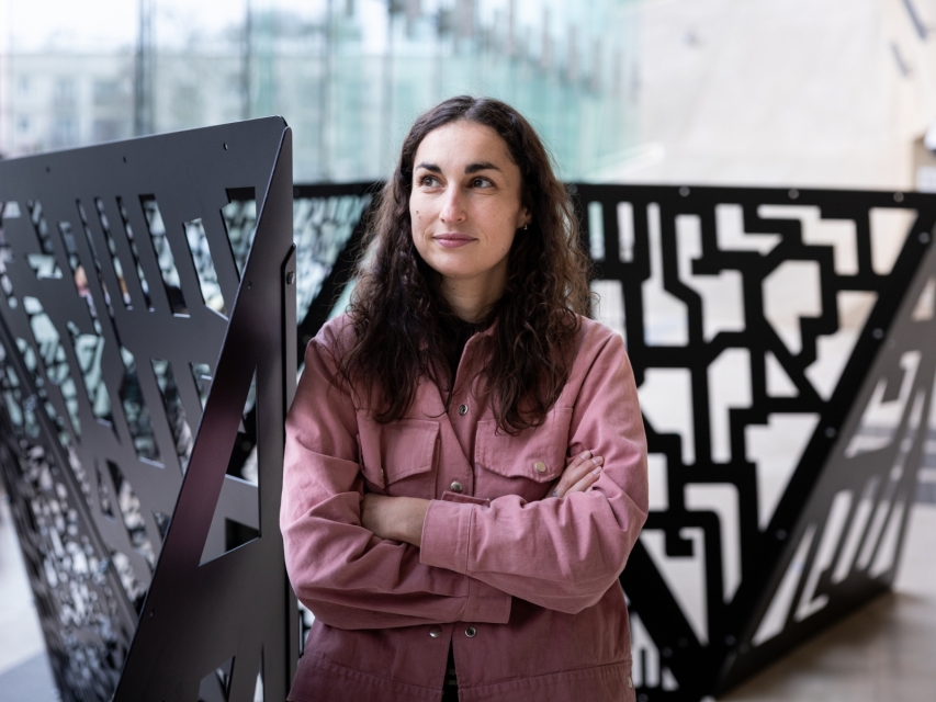 Klaudia Kiercz-Długołęcka stoi przy swojej pracy "I stała się światłość" prezentowanej w holu głównym Muzeum POLIN.