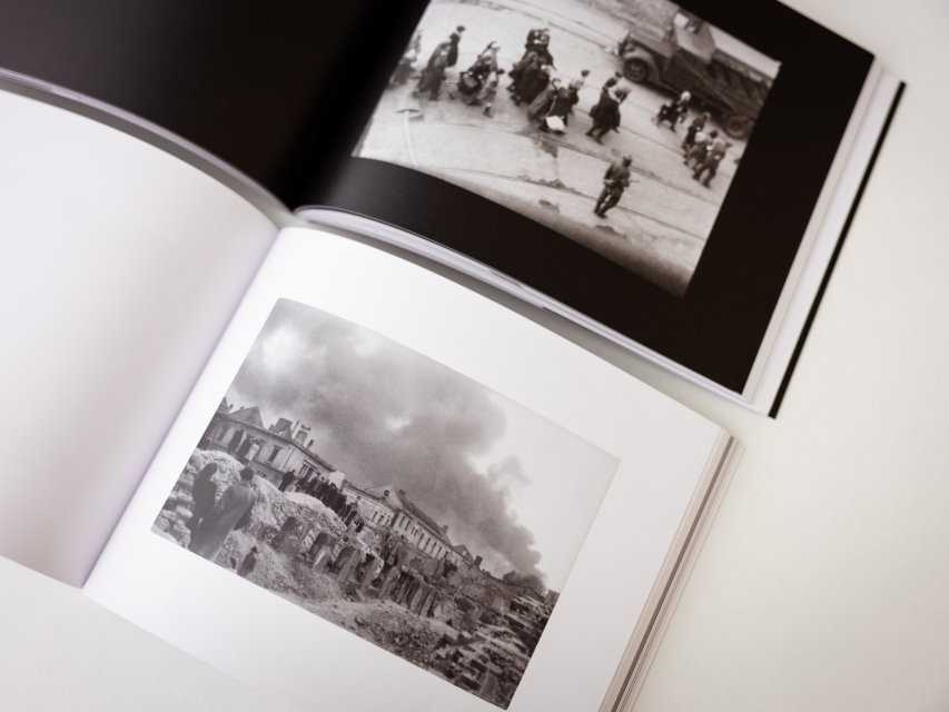 Dwa albumy - Dameca i Grzywaczewskiego - otwarte na wybranej fotografii z getta warszawskiego.