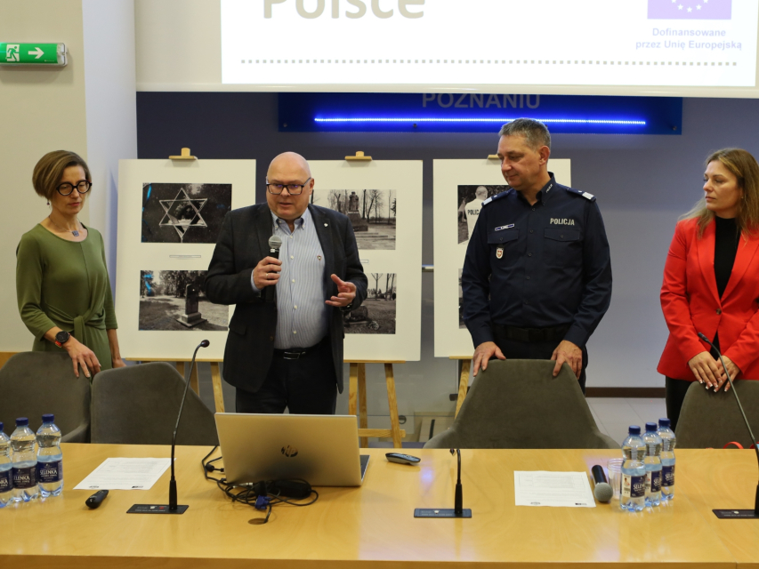 Czworo prowadzących stoi przy stole podczas szkolenia w ramach projektu BETAAEC.