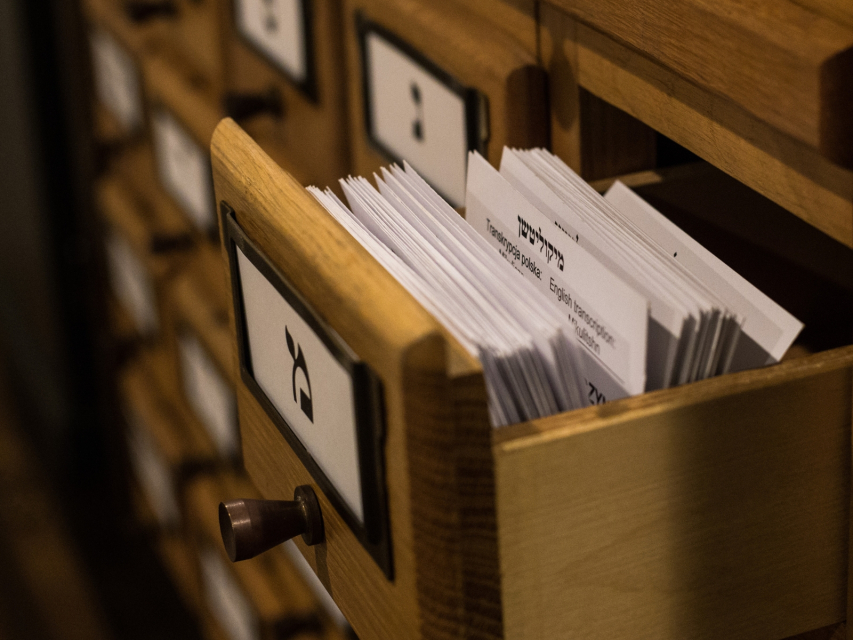 Kartoteka. Otwarta szuflada wypełniona kartkami z informacjami historycznymi.