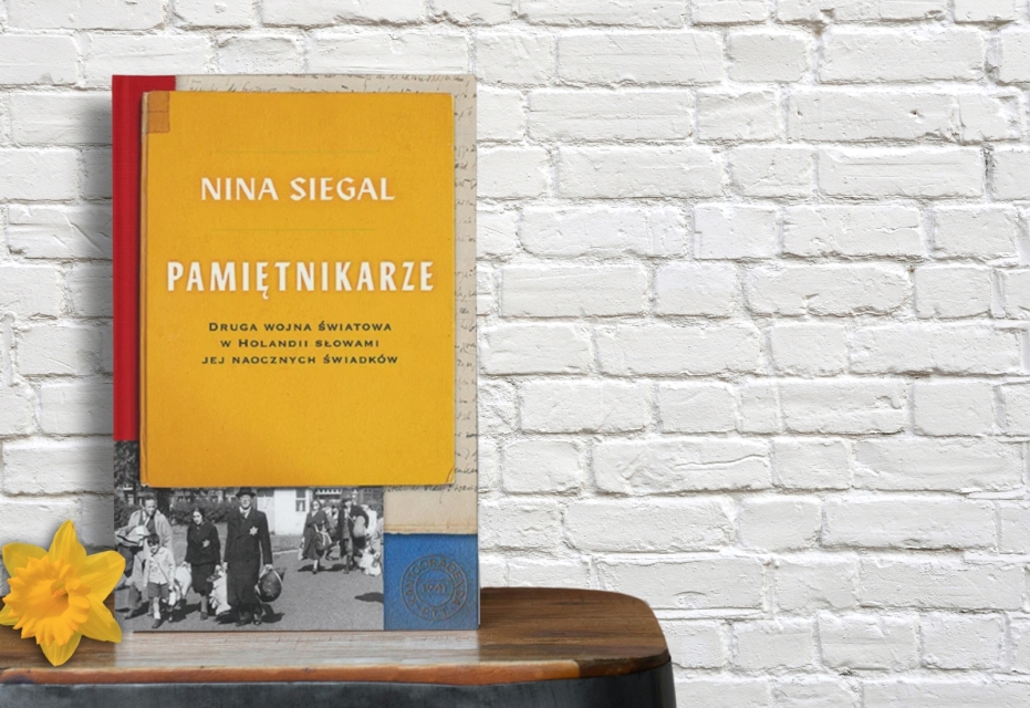 Na stoliku stoi książka "Pamiętnikarze". Obok niej leży żonkil.