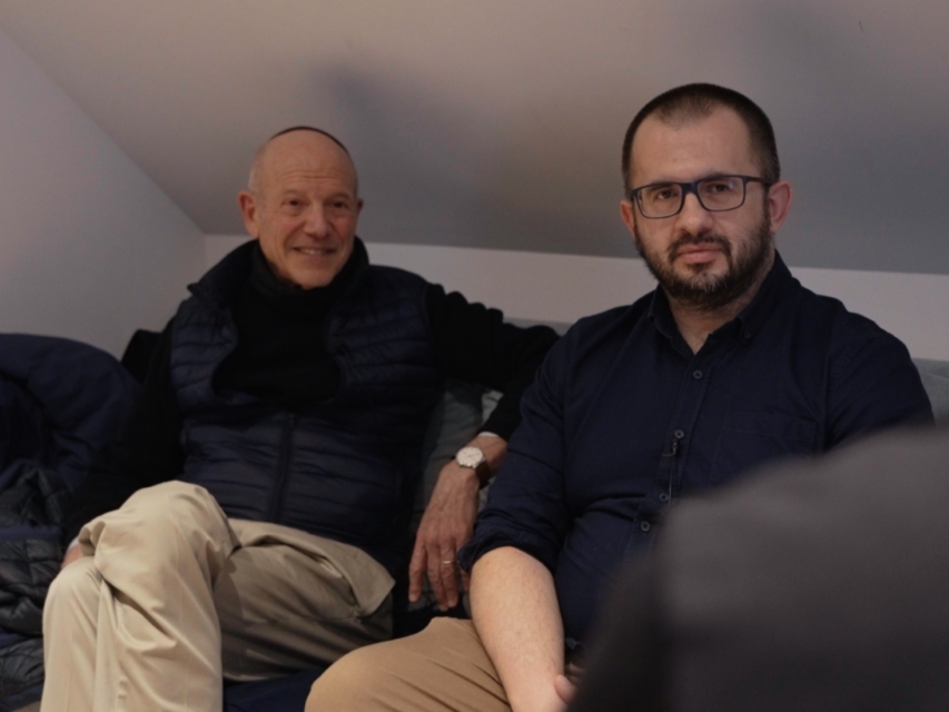 Kadr z etiudy. Na kanapie siedzą dwaj mężczyźni ubrani na czarno - Joseph Gellman i Przemysław Jaczewski.
