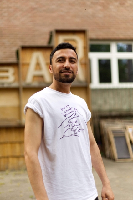 Omaid - szef kuchni Bazy Inclusive - na tle budynku.