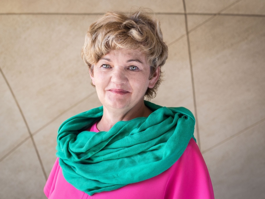 Jolanta Bilska na tle krzywoliniowej ściany w holu głównym Muzeum POLIN.
