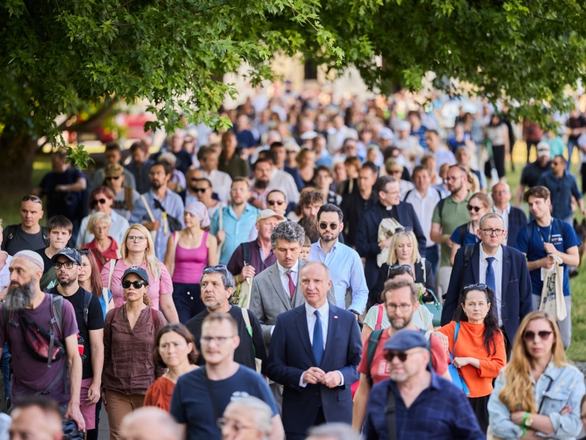 Grupa osób idzie ulicą Warszawy podczas Marszu Pamięci.