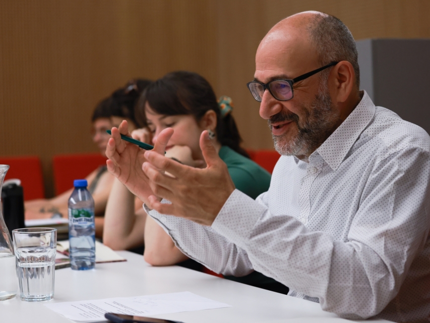 A man sitting next to two women during 2024 GEOP workshop.