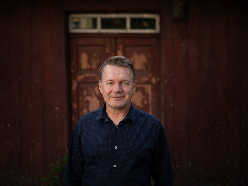 Dariusz Sobczyk stoi przed drzwiami do jakiegoś domu.
